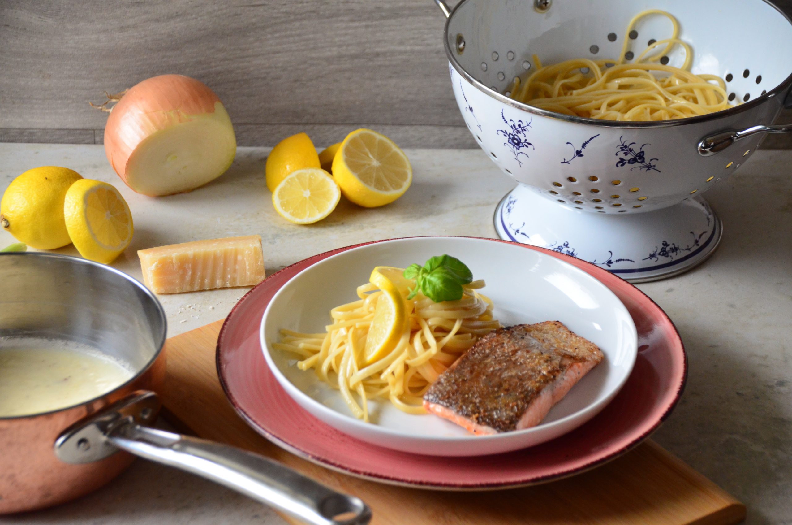 Gebratener Lachs mit Zitronenpasta, Zitronen und Küchenutensilien