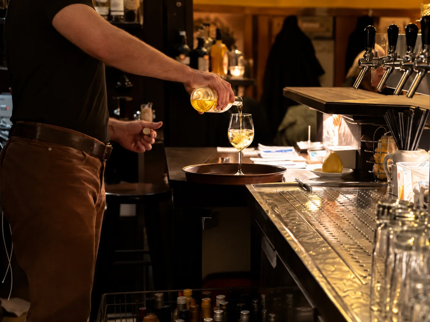 Service in Bewegung: Ein Getränk wird hinter der Bar eingeschenkt